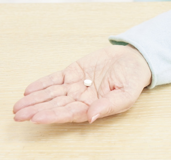 手のひらに錠剤を乗せている写真